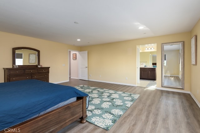 bedroom featuring light hardwood / wood-style floors and connected bathroom