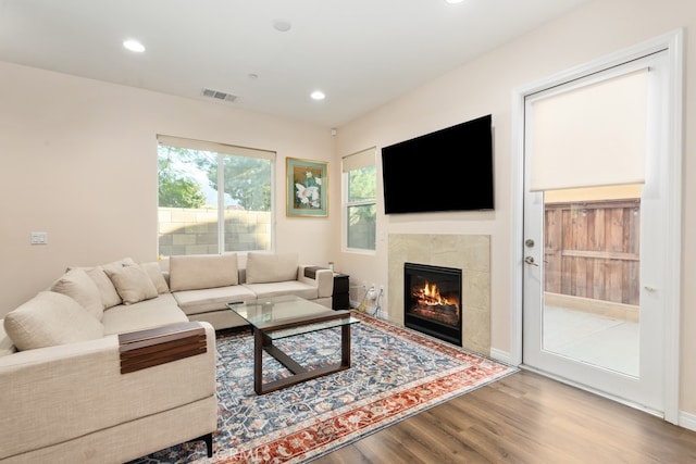 living room with hardwood / wood-style floors and a tile fireplace