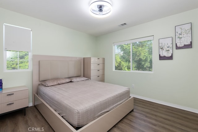 bedroom with dark hardwood / wood-style flooring