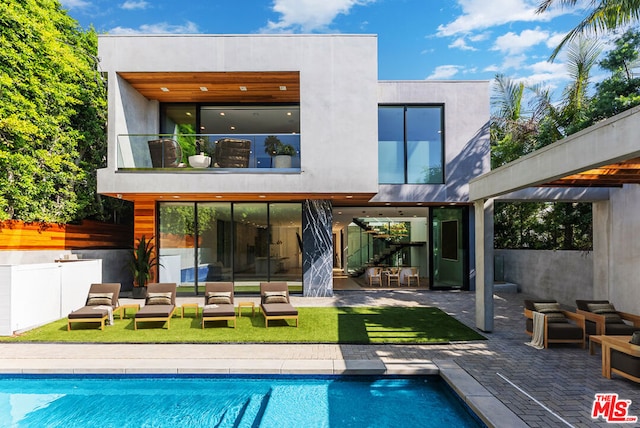 back of house with a lawn, a patio area, and a balcony