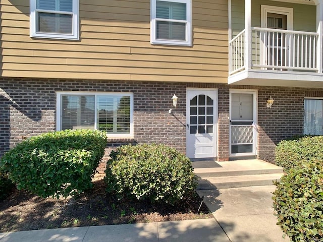 view of exterior entry with a balcony