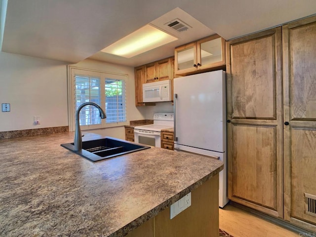 kitchen featuring sink, light hardwood / wood-style floors, and white appliances