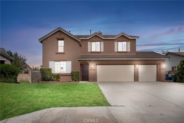 front of property with a yard and a garage