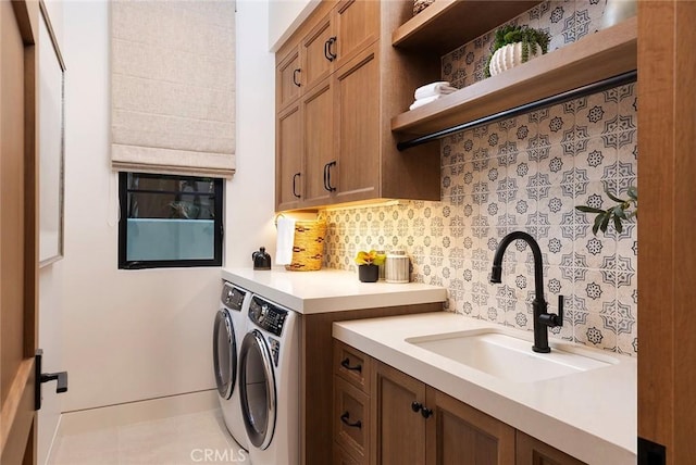 laundry room featuring separate washer and dryer, sink, and cabinets