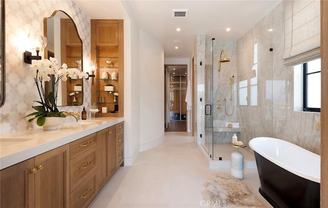 bathroom featuring vanity and independent shower and bath