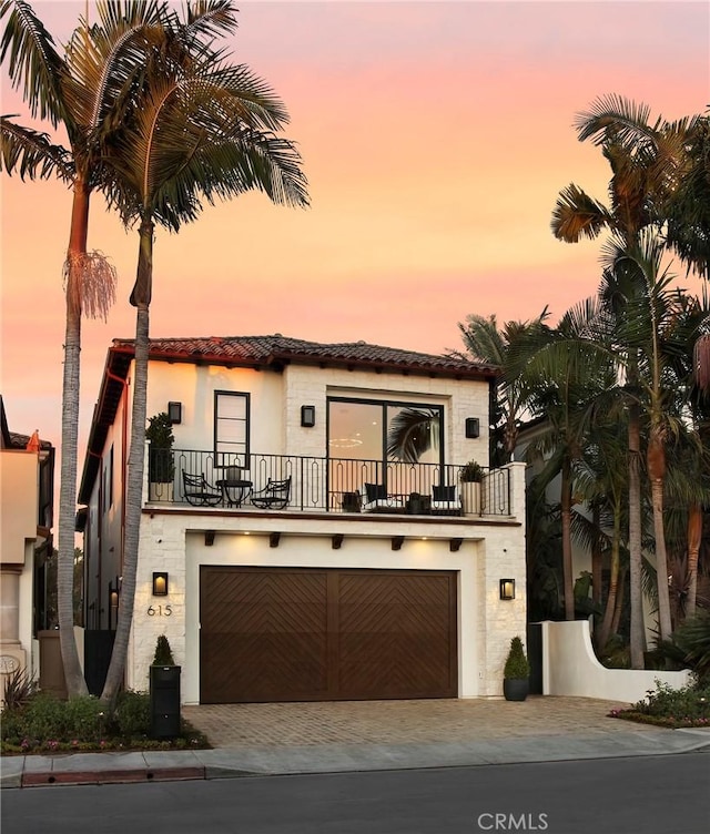 mediterranean / spanish-style home with a balcony and a garage