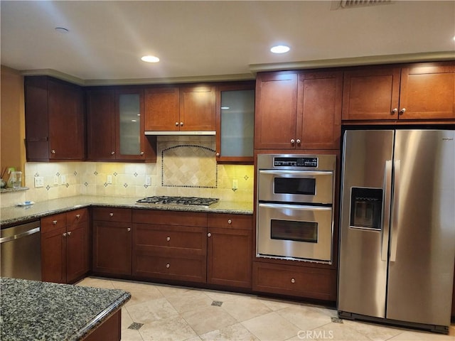 kitchen featuring tasteful backsplash, appliances with stainless steel finishes, and stone counters