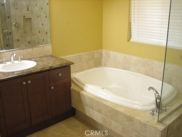 bathroom with vanity and independent shower and bath