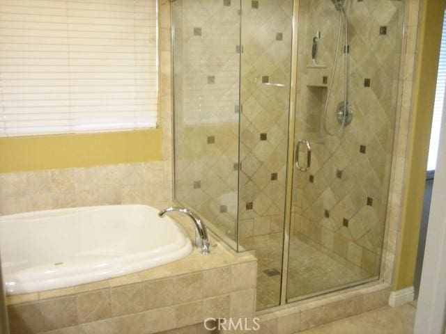 bathroom featuring shower with separate bathtub