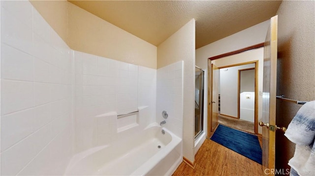 bathroom with hardwood / wood-style flooring, separate shower and tub, and a textured ceiling