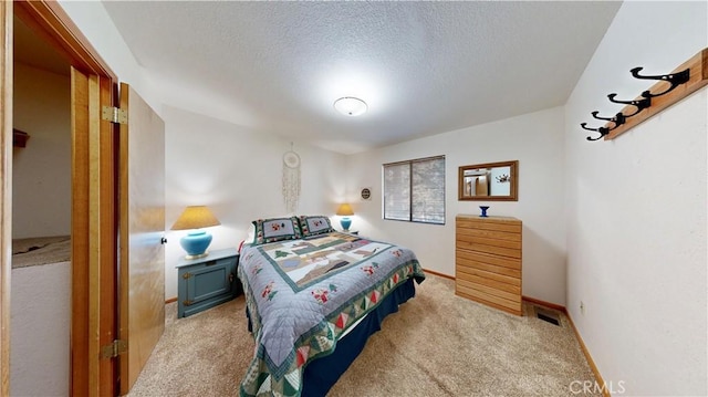 bedroom with light carpet and a textured ceiling