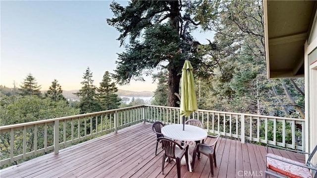 deck at dusk featuring a water view