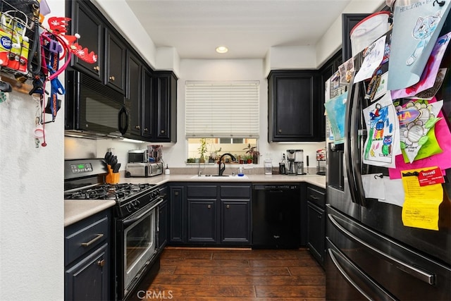 kitchen featuring sink, black appliances, and dark wood-type flooring