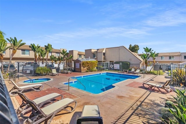 view of swimming pool with a patio and a hot tub