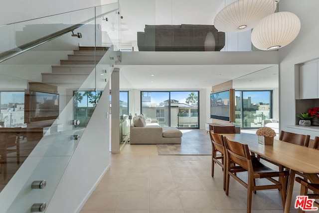 tiled dining space featuring a towering ceiling