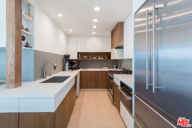 kitchen with white cabinets, light tile patterned floors, stainless steel appliances, and sink