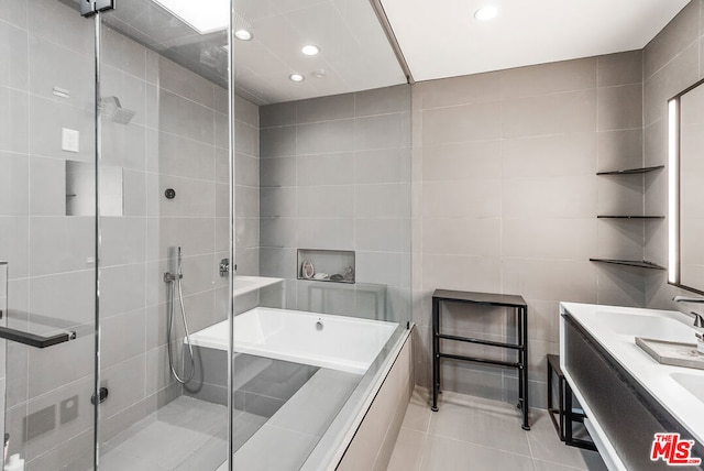 bathroom featuring tile patterned floors, independent shower and bath, and tile walls