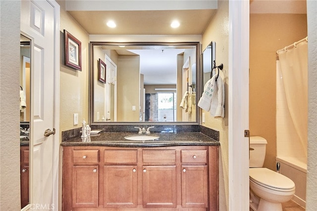 full bathroom featuring toilet, shower / bath combo with shower curtain, and vanity