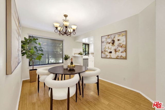 dining space featuring light hardwood / wood-style floors and an inviting chandelier