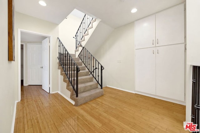 staircase with hardwood / wood-style flooring