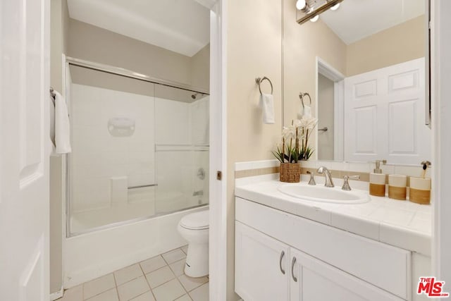 full bathroom with shower / bath combination with glass door, vanity, tile patterned flooring, and toilet