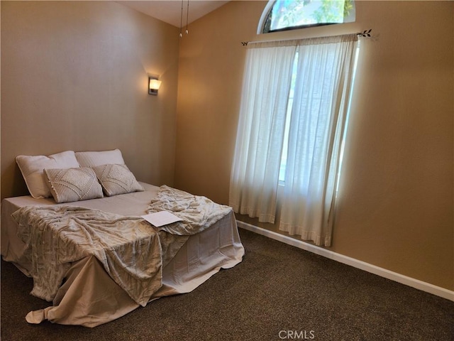 carpeted bedroom featuring multiple windows and lofted ceiling