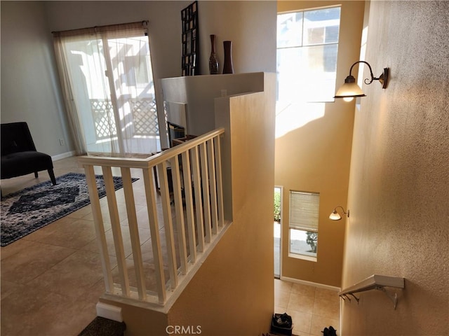 stairs featuring tile patterned flooring and a healthy amount of sunlight