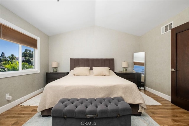 bedroom with wood-type flooring and vaulted ceiling