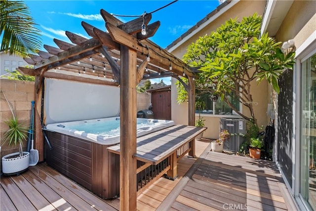 wooden terrace featuring a hot tub, cooling unit, and a pergola