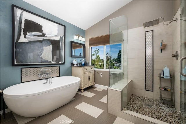 bathroom with tile patterned floors, lofted ceiling, shower with separate bathtub, and vanity