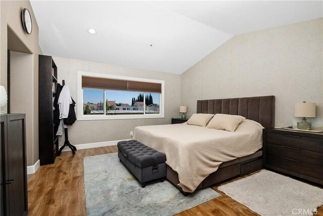 bedroom featuring lofted ceiling and hardwood / wood-style flooring