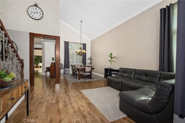 living room with a notable chandelier, crown molding, wood-type flooring, and vaulted ceiling