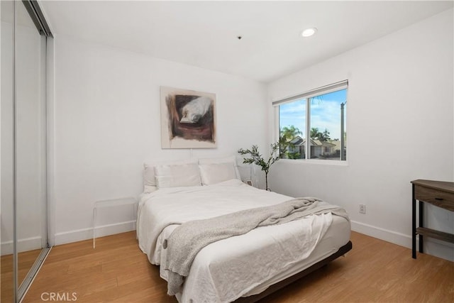 bedroom with wood-type flooring and a closet