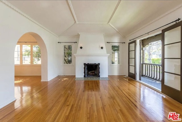 unfurnished living room with ornamental molding, lofted ceiling, and wood-type flooring