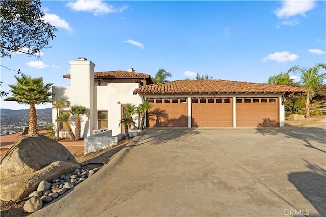 mediterranean / spanish-style house with a garage