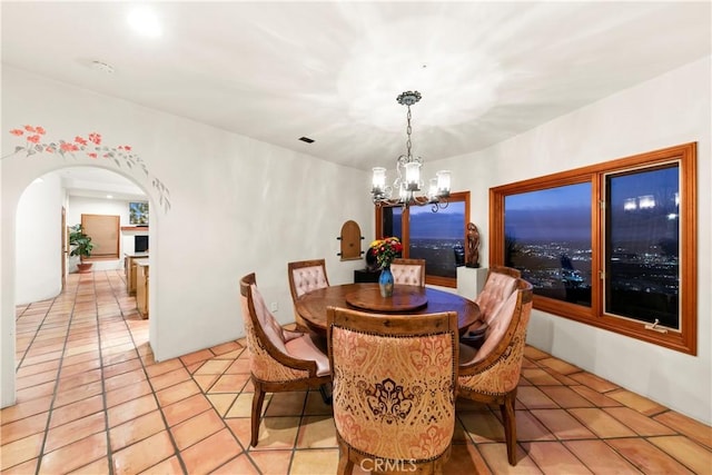 dining space featuring light tile patterned flooring and a chandelier