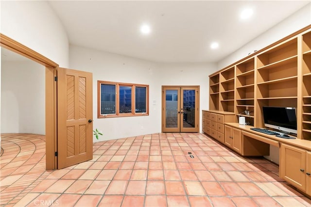 unfurnished office featuring built in desk, light tile patterned floors, and french doors