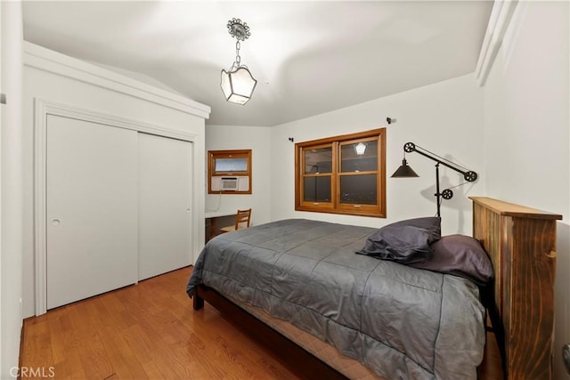 bedroom featuring wood-type flooring, a closet, and cooling unit