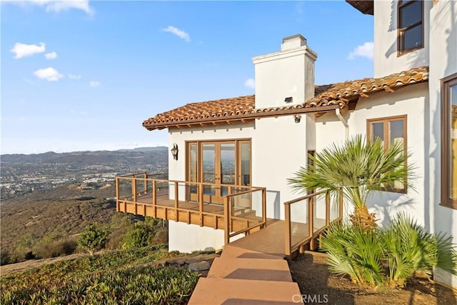 back of house featuring a mountain view, a balcony, and french doors