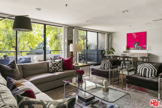 living room with floor to ceiling windows and a textured ceiling