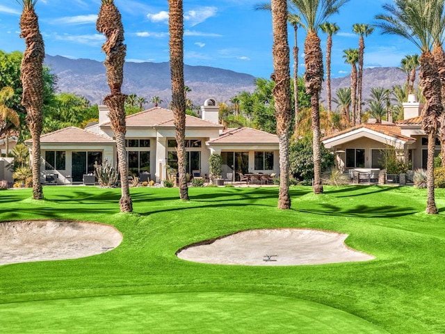 view of property's community with a mountain view and a yard