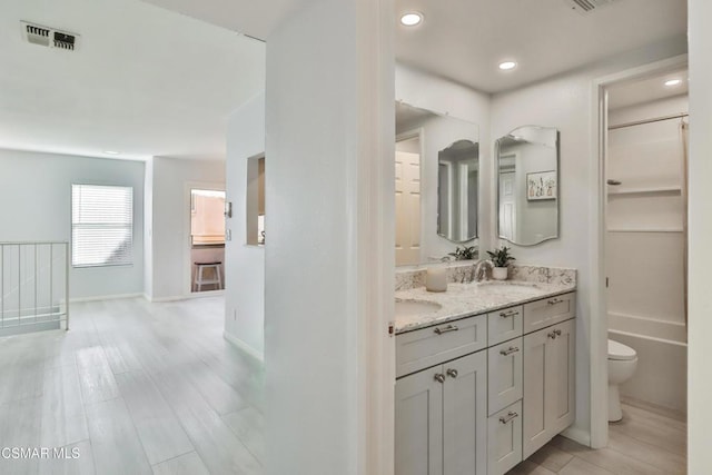 bathroom with wood-type flooring, toilet, and vanity