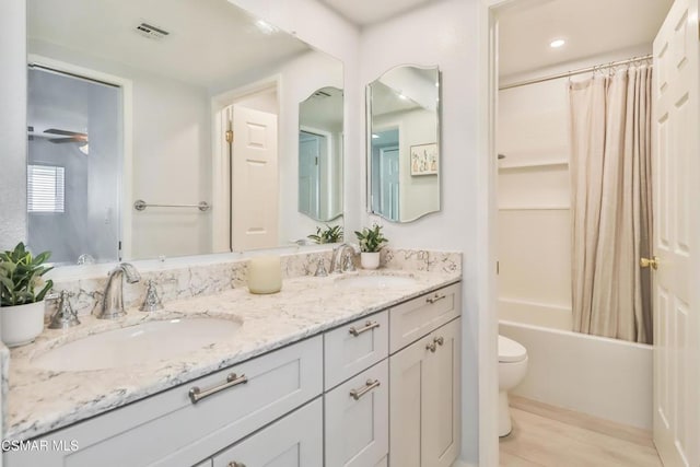 full bathroom with vanity, hardwood / wood-style floors, shower / tub combo, and toilet