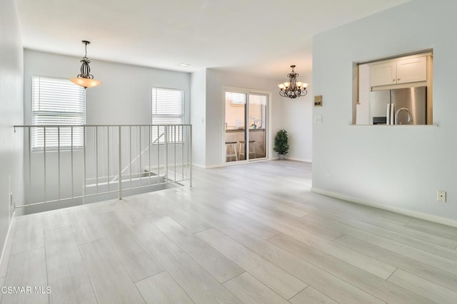 unfurnished room featuring light hardwood / wood-style flooring and a chandelier