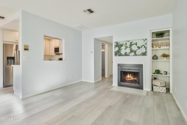 unfurnished living room with light wood-type flooring