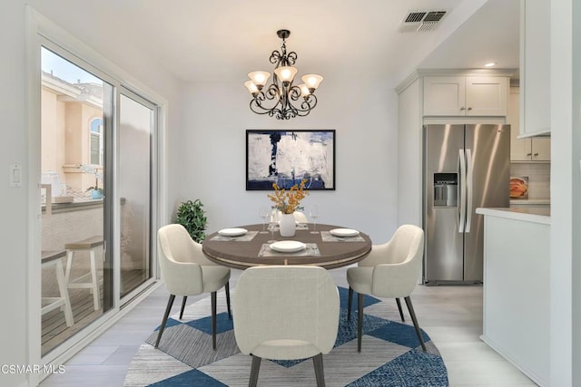 dining area with an inviting chandelier and light hardwood / wood-style floors