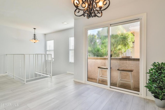 entryway with light hardwood / wood-style floors and a chandelier