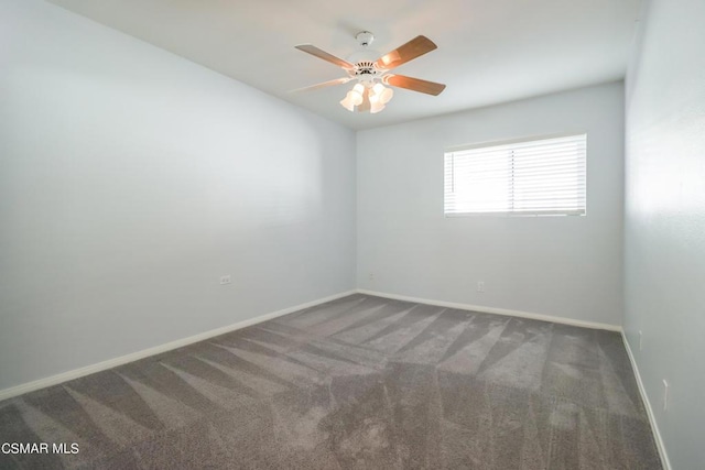 spare room featuring ceiling fan and dark carpet