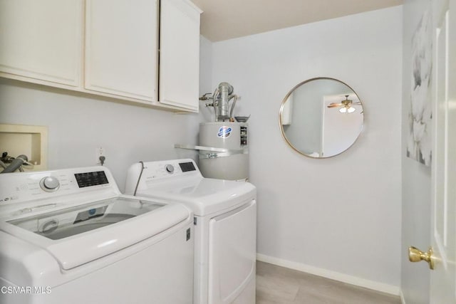 laundry room with cabinets, separate washer and dryer, and gas water heater