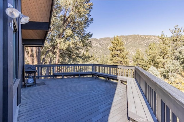 wooden deck with area for grilling and a mountain view